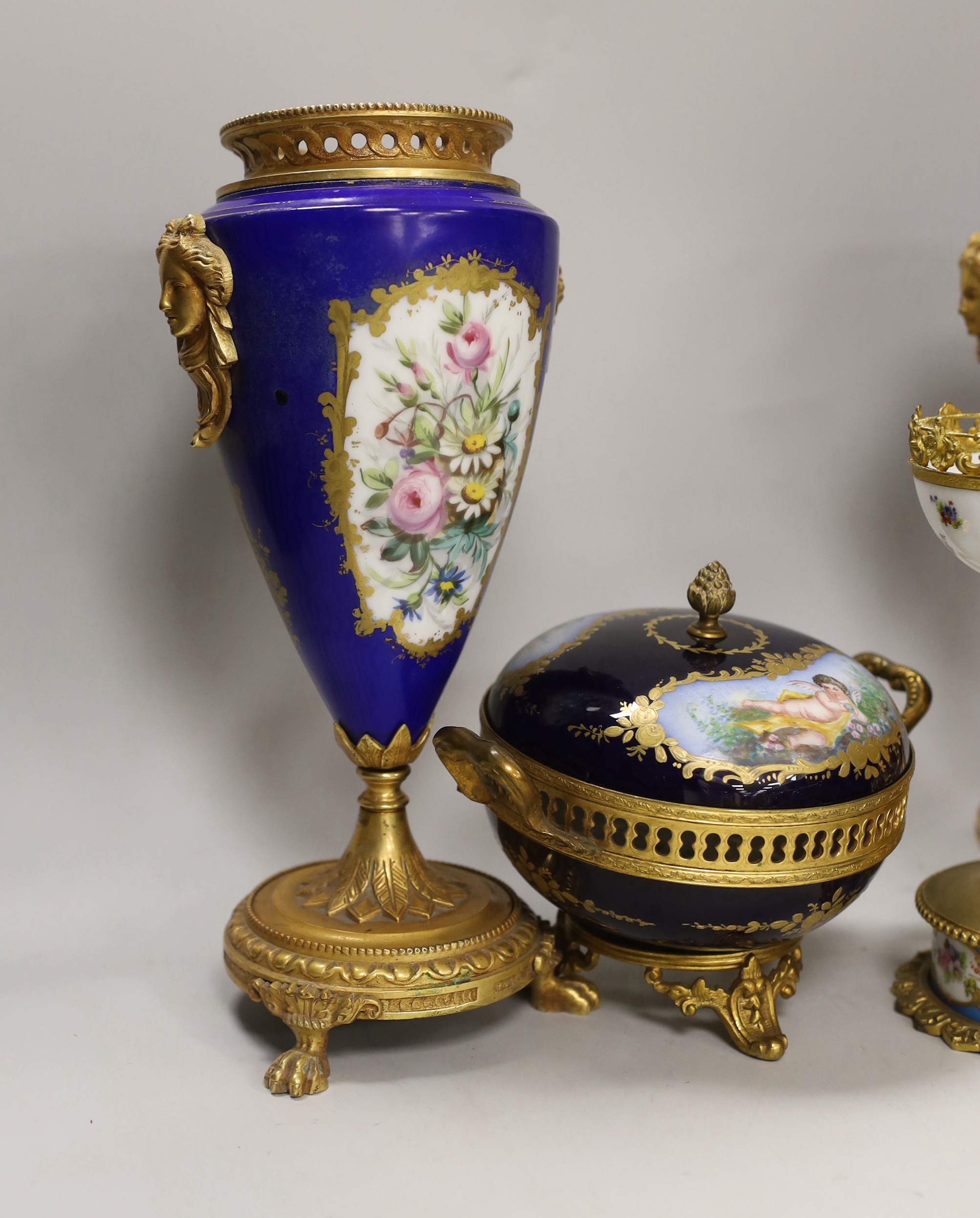 A pair of Sevres style porcelain ormolu mounted vases, a similar putti stemmed cup and a bowl and cover, tallest 27cm